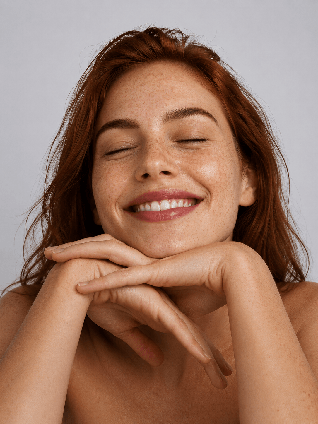 Woman with closed eyes smiling against a plain background - gentle natural skincare for everyday use