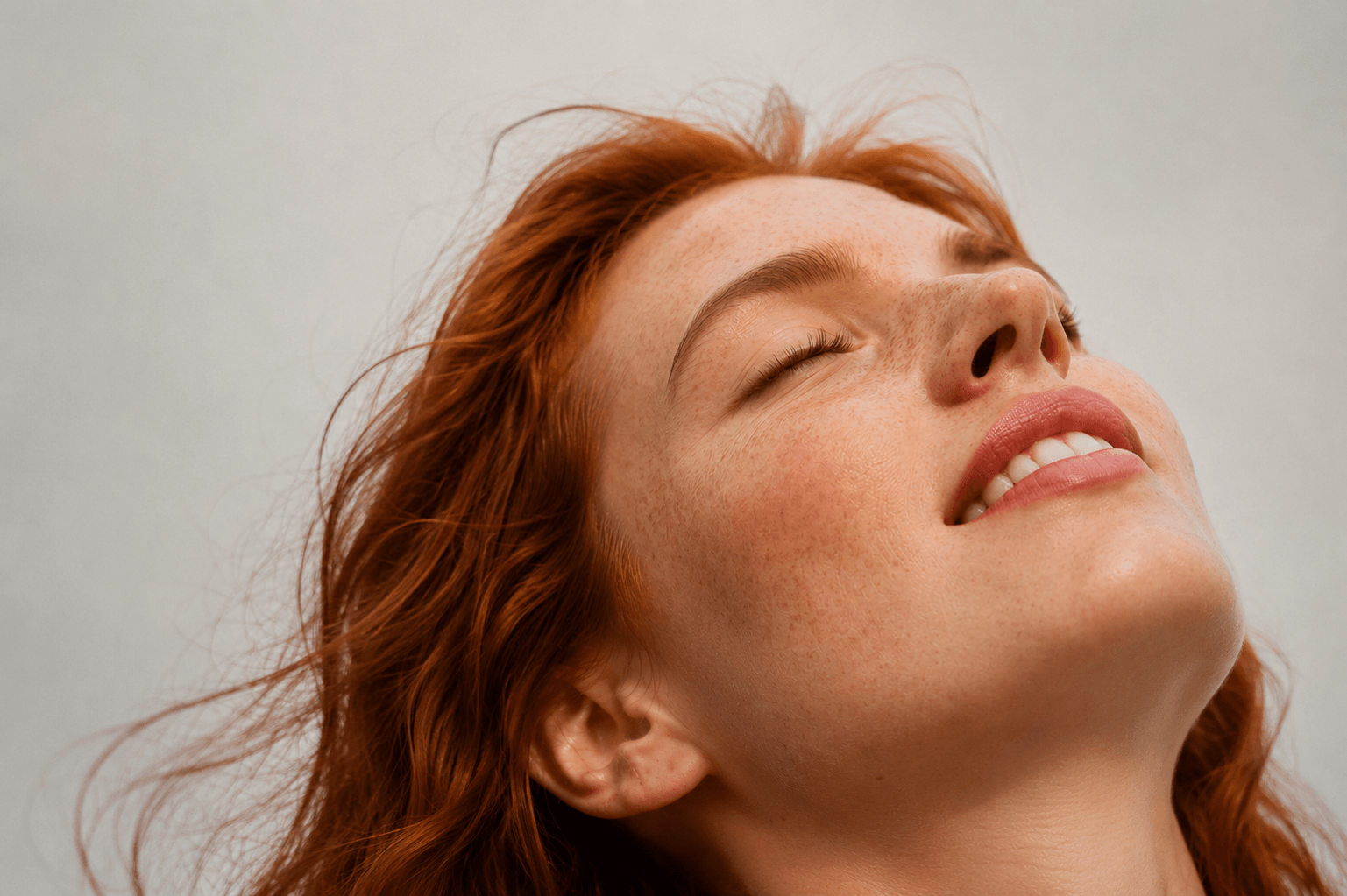 Woman with red hair looking upwards against a plain background Suvera Skincare, Bureau Veritas certified, vegan skincare
