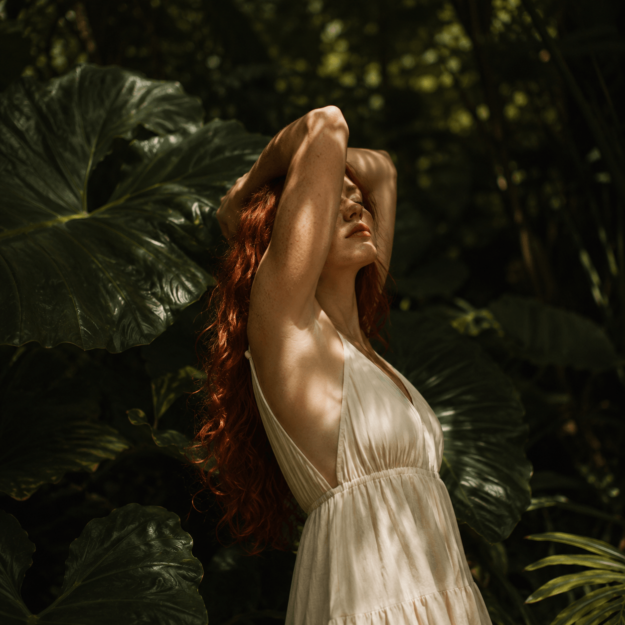 Woman in a white dress standing among large green leaves Suvera Skincare