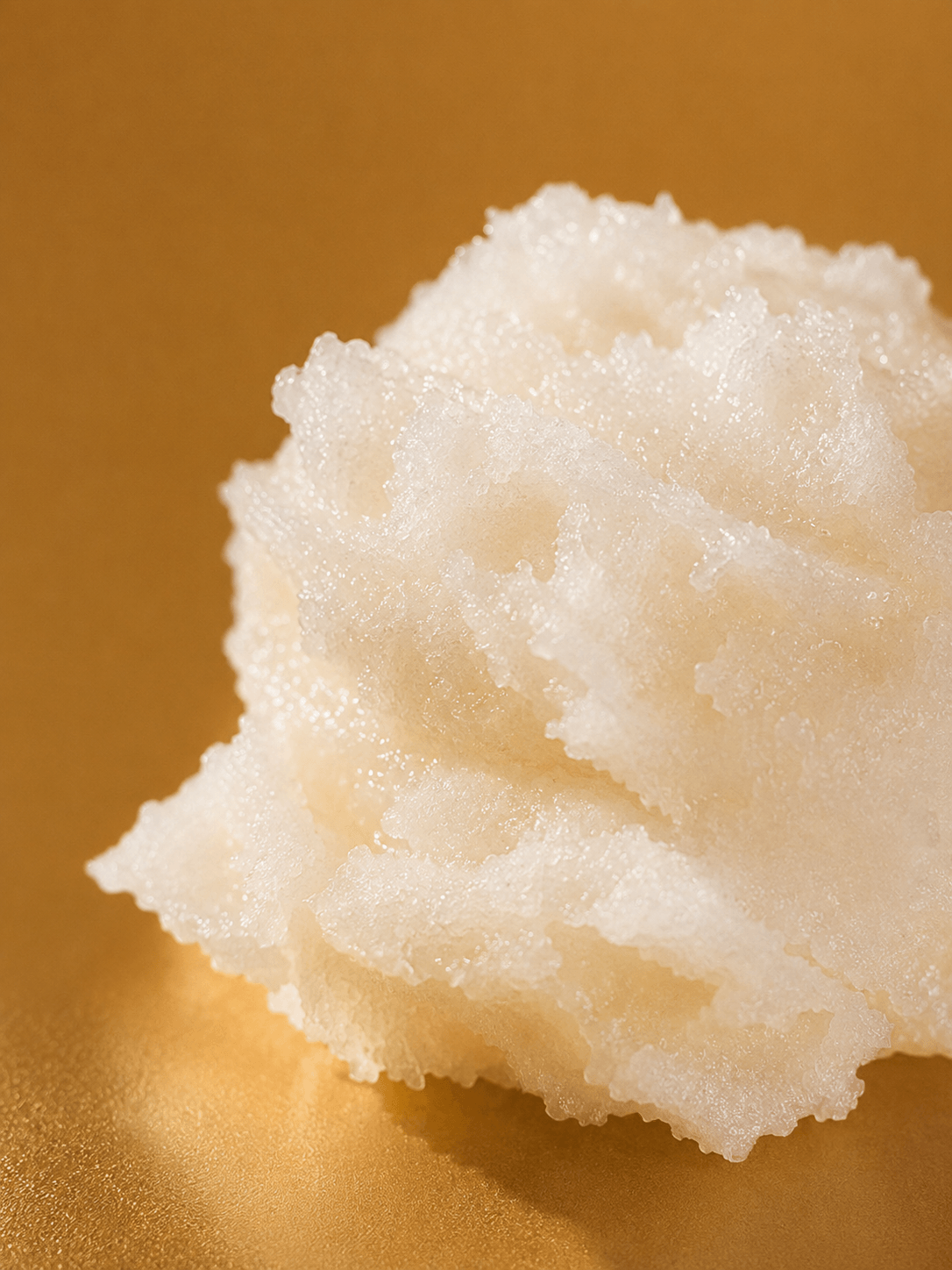 Close-up of a scoop of vanilla salt skincare cream on a gold background Suvera Skincare, vegan skincare, nut-free skincare