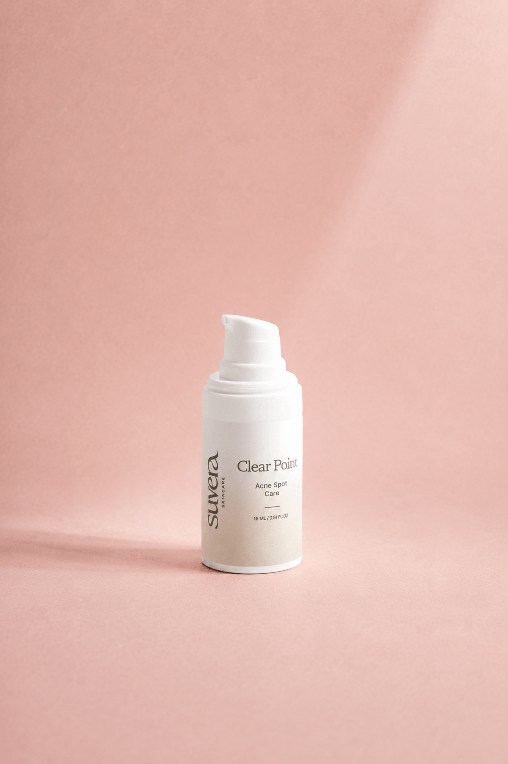 A white pump bottle of Suvea Clear Skin Care Clear Skin Cream standing on a dusty pink background with soft diagonal shadows.